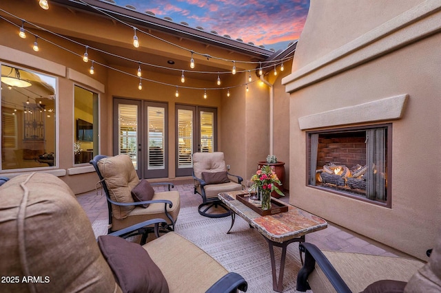 view of patio / terrace with an outdoor living space with a fireplace and french doors