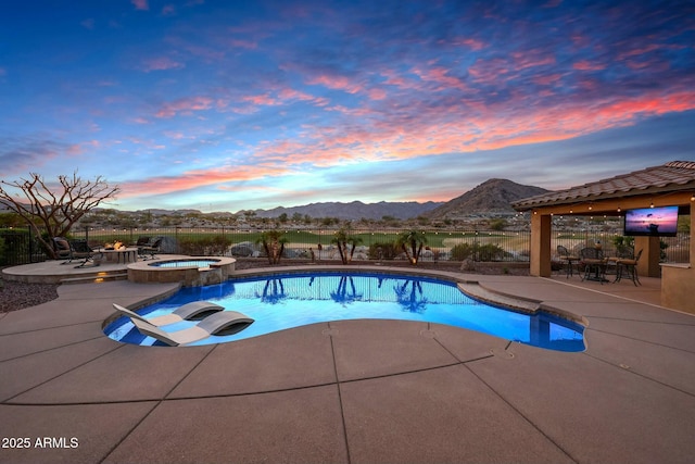 view of pool featuring a patio area, a pool with connected hot tub, and fence