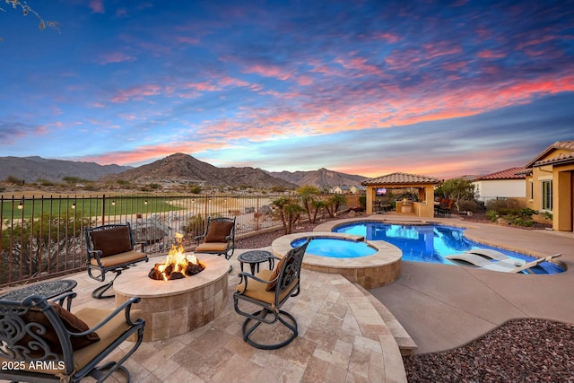 view of pool featuring a fire pit, fence, a gazebo, a patio area, and a mountain view