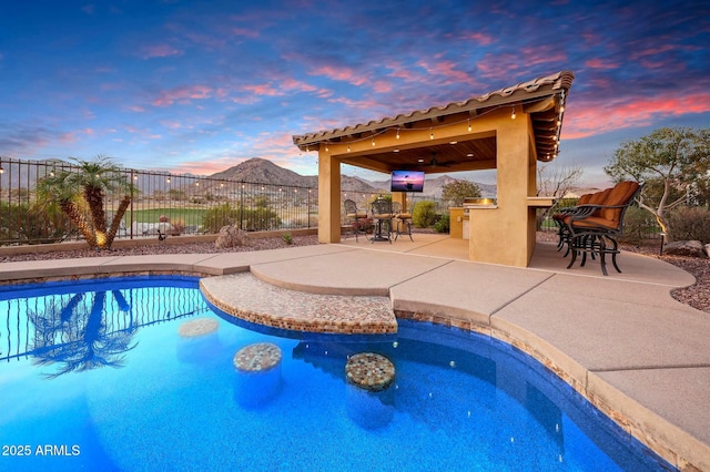 view of swimming pool with a patio, fence, a ceiling fan, outdoor dry bar, and a fenced in pool