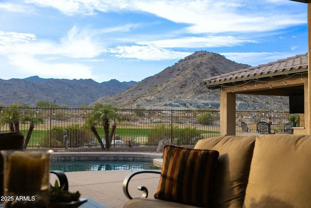 view of pool featuring an outdoor hangout area, a patio, fence, and a mountain view