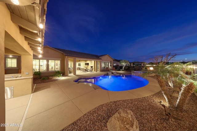 pool at twilight featuring a patio, area for grilling, and an outdoor pool