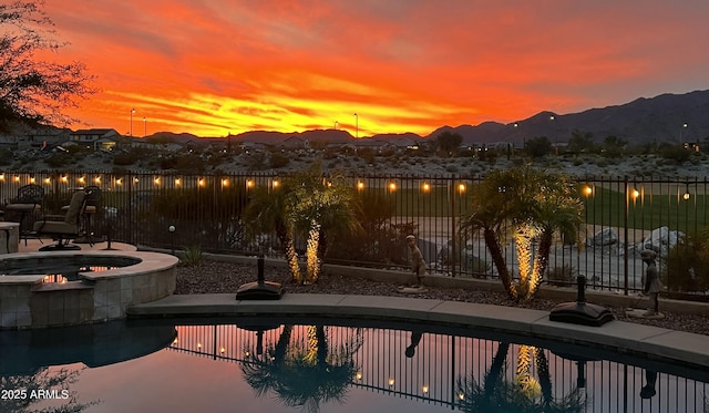 view of swimming pool featuring a patio area, fence, and a mountain view