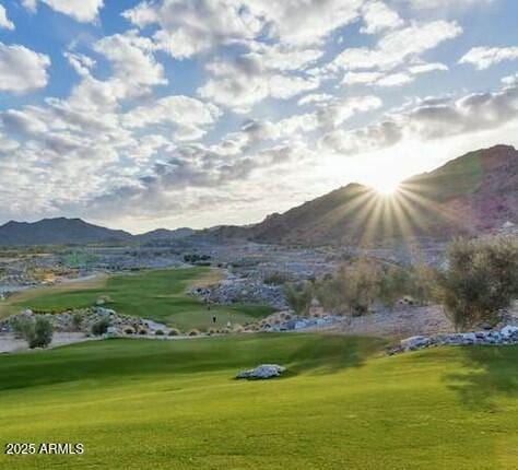 exterior space with a yard, golf course view, and a mountain view