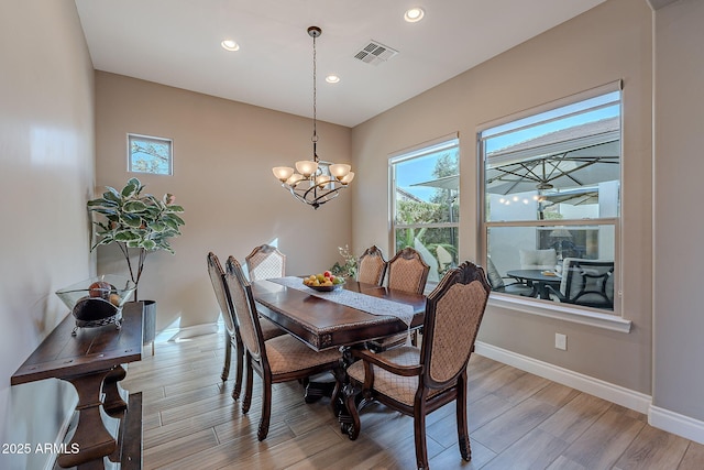 dining space featuring a notable chandelier, plenty of natural light, and light wood-type flooring