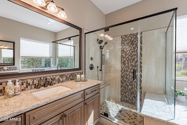 bathroom featuring an enclosed shower, vanity, and backsplash