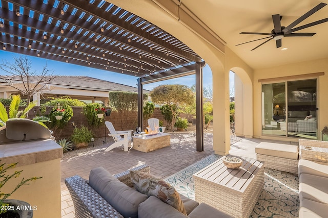 view of patio with an outdoor living space with a fire pit, ceiling fan, and a pergola