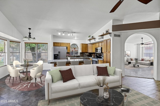 1245 W Cindy St, Chandler, AZ 85224 - living room with a ceiling fan, vaulted ceiling, arched walkways, and a chandelier