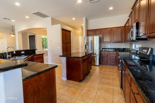 4241 E Andre Ave, Gilbert, AZ 85298 - kitchen featuring stainless steel appliances, a kitchen island, plenty of natural light, arched walkways, and recessed lighting