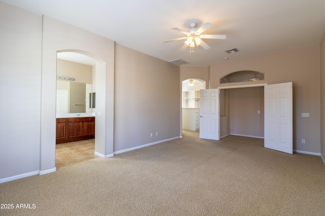4241 E Andre Ave, Gilbert, AZ 85298 - unfurnished bedroom featuring arched walkways, light carpet, and ensuite bathroom