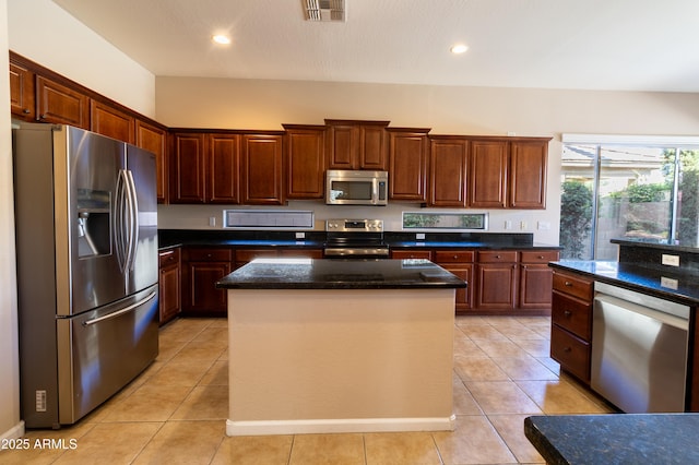 4241 E Andre Ave, Gilbert, AZ 85298 - kitchen with stainless steel appliances, a kitchen island, light tile patterned floors, dark stone countertops, and recessed lighting