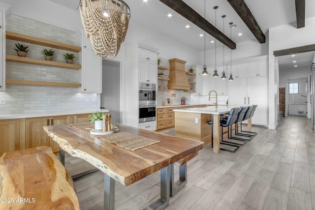 35150 N Bell Rd, Queen Creek, AZ 85144 - kitchen featuring open shelves, custom exhaust hood, light countertops, double oven, and beamed ceiling