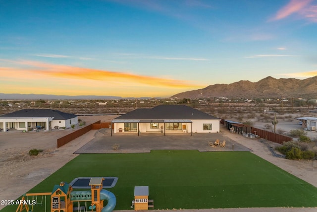 view of front of property with a gazebo, a patio, a fenced backyard, and a mountain view