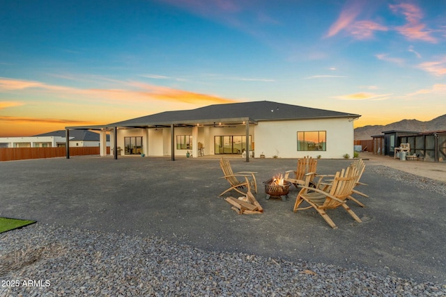 35150 N Bell Rd, Queen Creek, AZ 85144 - back of house at dusk with a patio, stucco siding, fence, and an outdoor fire pit