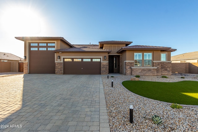 prairie-style home with a garage and a front yard