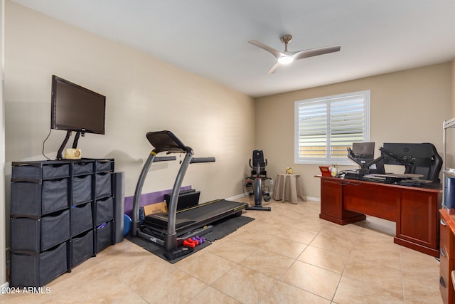 exercise area with light tile patterned floors and ceiling fan