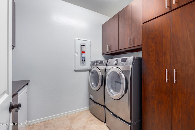 laundry area featuring cabinets, light tile patterned floors, and washing machine and dryer