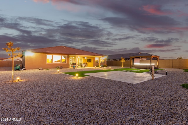 back house at dusk with a patio