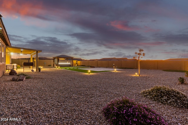 yard at dusk with a gazebo and a patio area