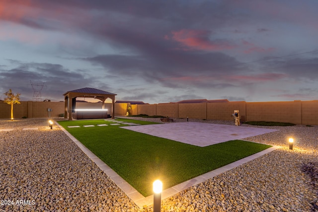 yard at dusk featuring a gazebo