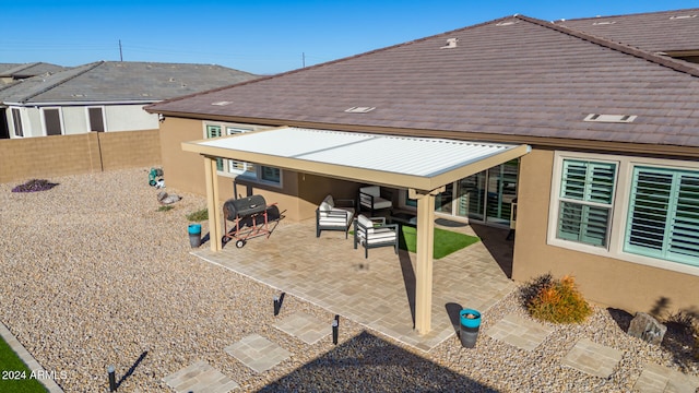 rear view of property featuring an outdoor living space and a patio area