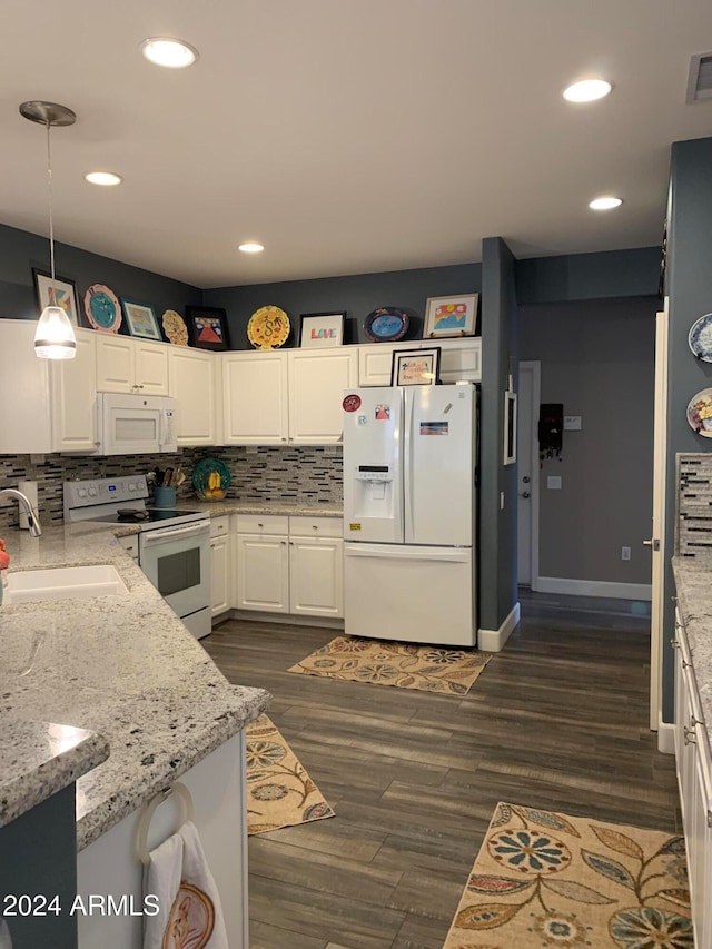 kitchen featuring white appliances, dark wood-type flooring, white cabinets, sink, and decorative light fixtures