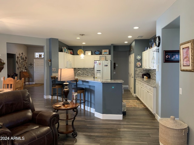 kitchen featuring decorative light fixtures, dark hardwood / wood-style floors, white appliances, and backsplash