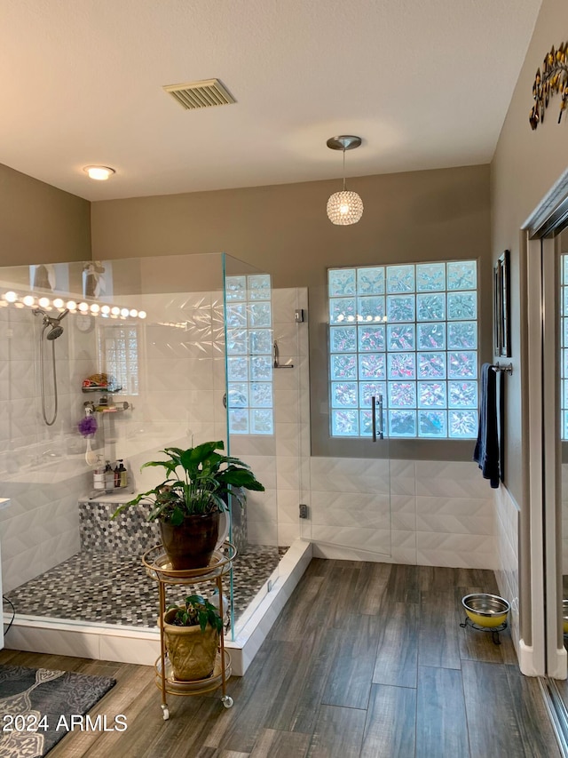 bathroom with hardwood / wood-style floors and a shower with shower door