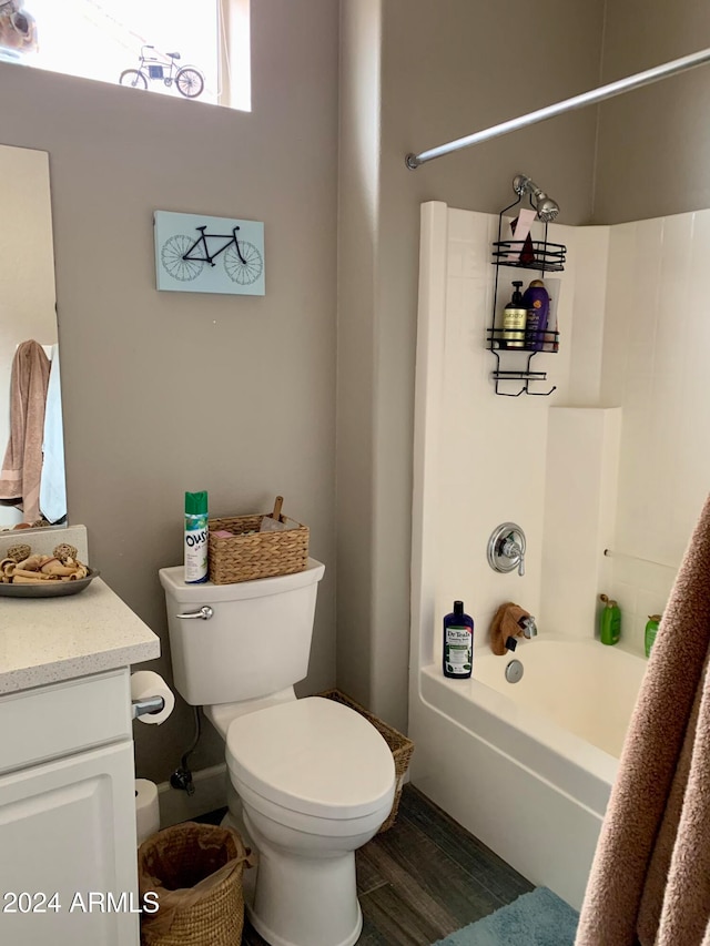 full bathroom with hardwood / wood-style flooring, shower / washtub combination, vanity, and toilet