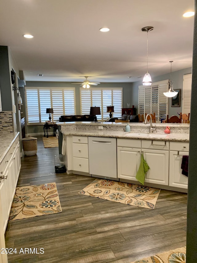 kitchen featuring dark wood-type flooring, white dishwasher, white cabinets, ceiling fan, and light stone countertops