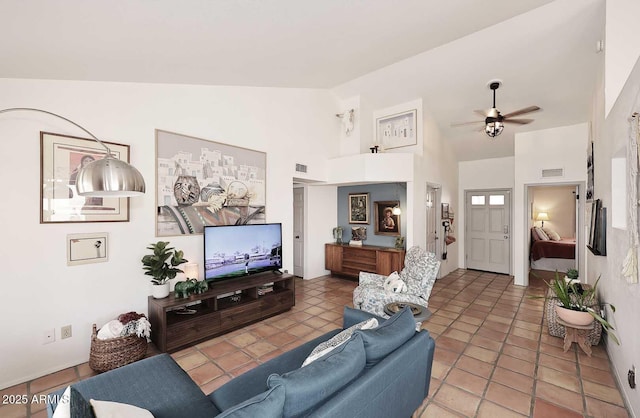 living room featuring a ceiling fan, visible vents, and high vaulted ceiling