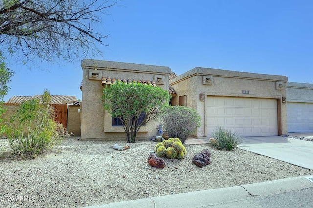 view of front of house with stucco siding, an attached garage, and concrete driveway