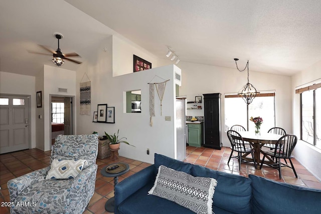 living room with lofted ceiling, light tile patterned floors, a ceiling fan, and a wealth of natural light