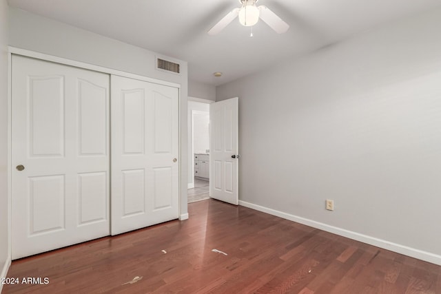 unfurnished bedroom featuring dark hardwood / wood-style flooring, a closet, and ceiling fan