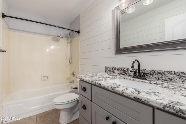 full bathroom featuring tile patterned floors, bathtub / shower combination, vanity, toilet, and wood walls