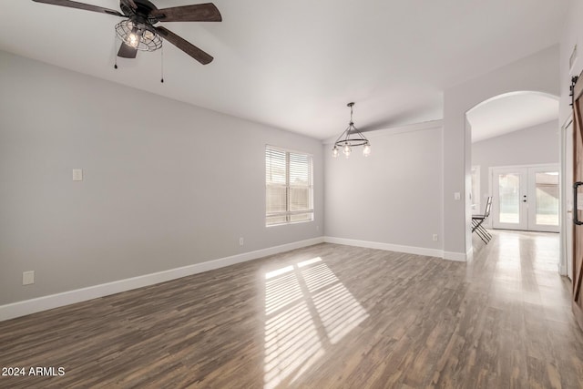 spare room with a barn door, french doors, a healthy amount of sunlight, and dark hardwood / wood-style floors