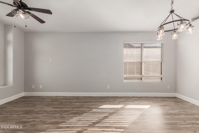 unfurnished room featuring ceiling fan with notable chandelier and wood-type flooring