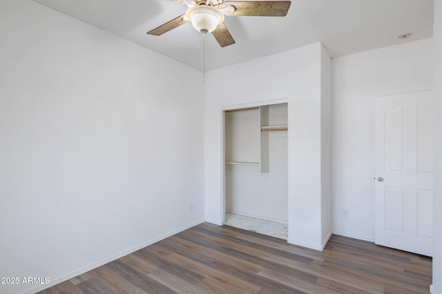 11669 N 165th Ave, Surprise, AZ 85388 - unfurnished bedroom featuring a closet, baseboards, wood finished floors, and a ceiling fan
