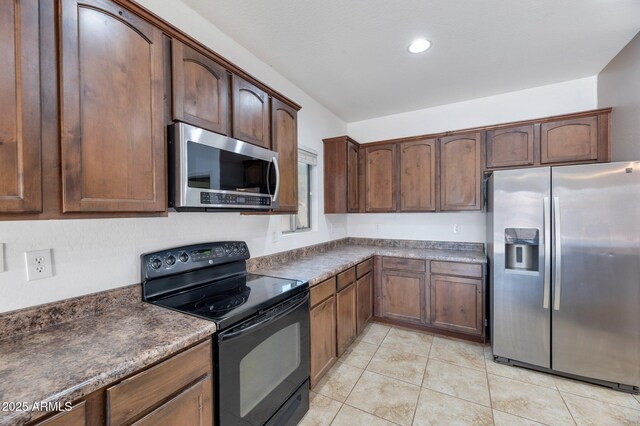 11669 N 165th Ave, Surprise, AZ 85388 - kitchen with light tile patterned floors, dark countertops, and appliances with stainless steel finishes