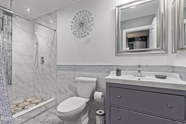 20769 N 106th Ln, Peoria, AZ 85382 - bathroom with vanity, a tile shower, tile walls, wainscoting, and marble finish flooring