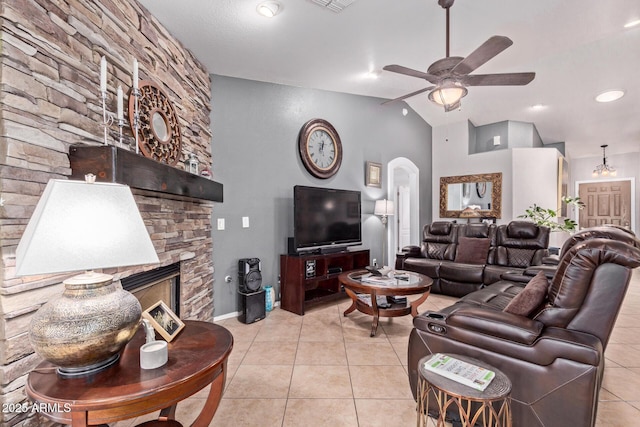 20769 N 106th Ln, Peoria, AZ 85382 - living room with light tile patterned flooring, ceiling fan, arched walkways, a stone fireplace, and vaulted ceiling