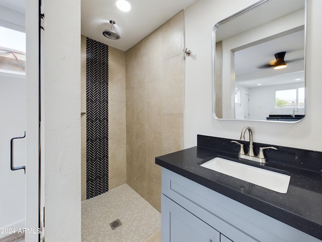 bathroom featuring a tile shower and vanity