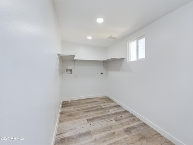 laundry area featuring electric dryer hookup, washer hookup, and light hardwood / wood-style flooring