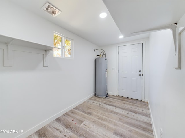 basement with water heater and light wood-type flooring