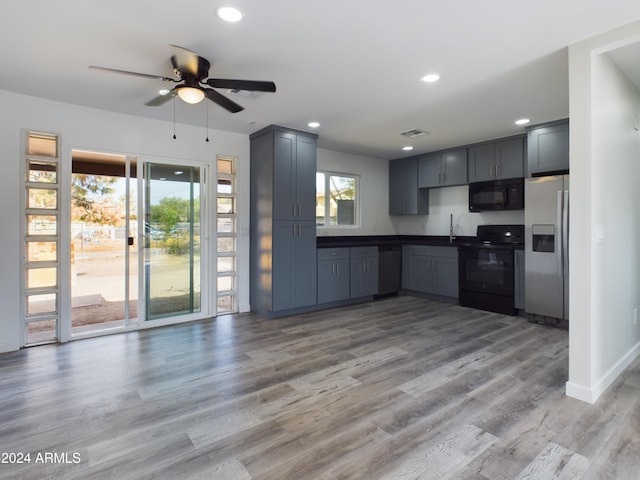 kitchen featuring sink, light hardwood / wood-style flooring, ceiling fan, gray cabinetry, and black appliances