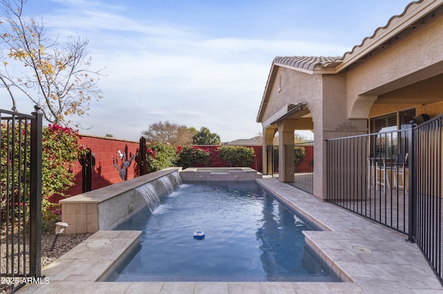 view of swimming pool featuring pool water feature and an in ground hot tub