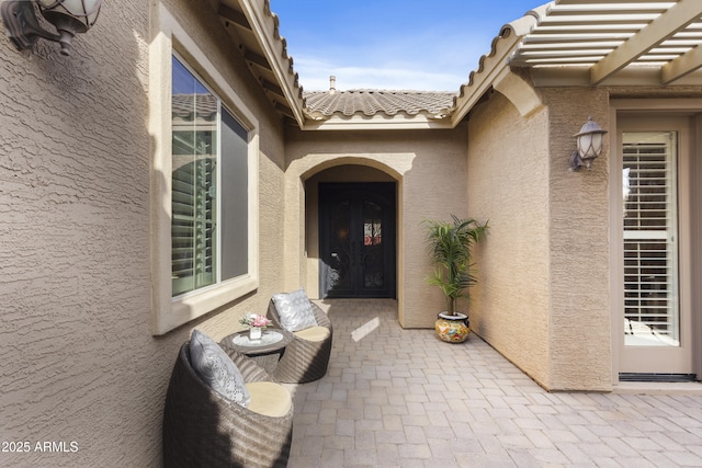 entrance to property with a pergola and a patio