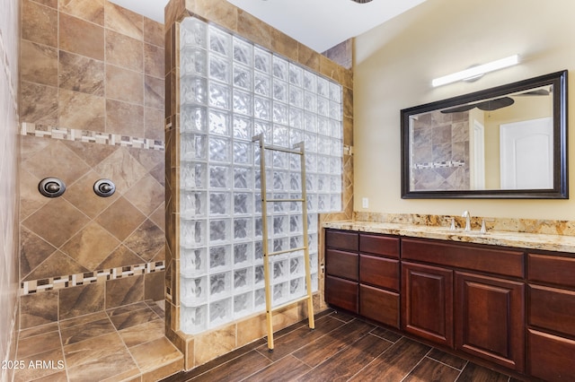 bathroom with vanity, hardwood / wood-style flooring, and a tile shower