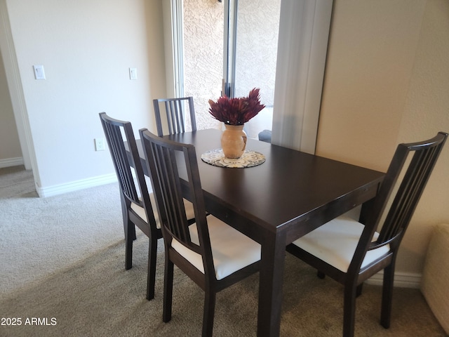 carpeted dining room with baseboards