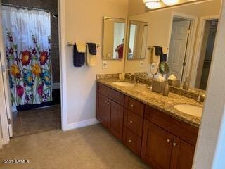 full bathroom with double vanity, curtained shower, baseboards, and a sink